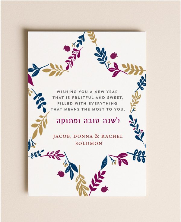 5x7 Rosh Hashanah flat card featuring a Star of David made of navy, plum, and gold botanical leaves with a custom holiday greeting next to a blank envelope.