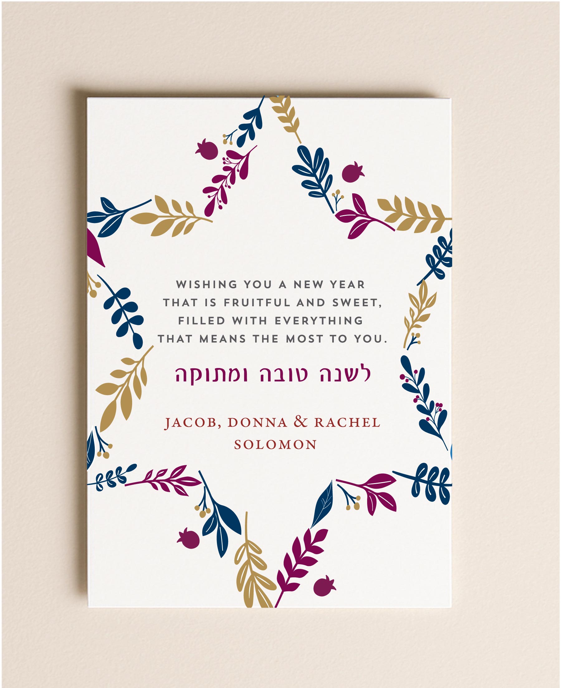 5x7 Rosh Hashanah flat card featuring a Star of David made of navy, plum, and gold botanical leaves with a custom holiday greeting next to a blank envelope.