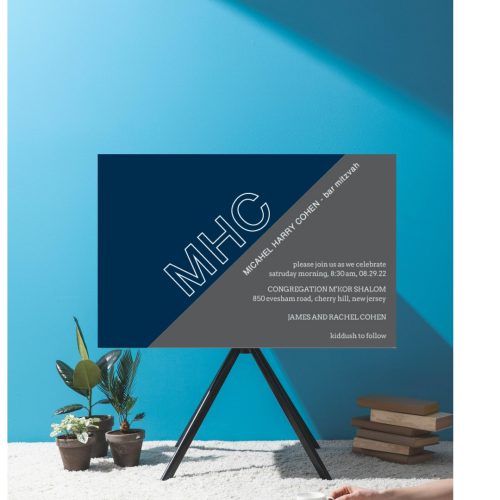 This sleek and modern Bar Mitzvah invitation features a striking design with an angled background, split between charcoal and navy. The dynamic color contrast adds sophistication, while the large monogram of the Bar Mitzvah boy takes center stage, bringing a cool and elegant touch to the card. The details of the celebration are thoughtfully laid out, creating a bold and memorable invitation for this special occasion.