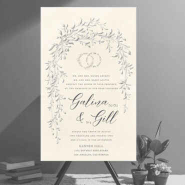 This is not a flat, digitally printed invitation—it's an embossed design that brings true dimension and artistry to the piece. The raised embossing adds depth and texture to a graceful sketch of trailing vines, arching over the text in the symbolic shape of a chuppah. Aptly named the Arched Foliage Chuppah Jewish Wedding Invitation, it captures tradition and elegance in every detail. At the top, the Hebrew phrase Ani L’dodi V’dodi Li (I am my beloved’s and my beloved is mine) appears in the shape of intertwined wedding rings, emphasizing unity and love. The wedding details are arranged in a refined layout, featuring elegant script fonts alongside the Hebrew names of the couple.