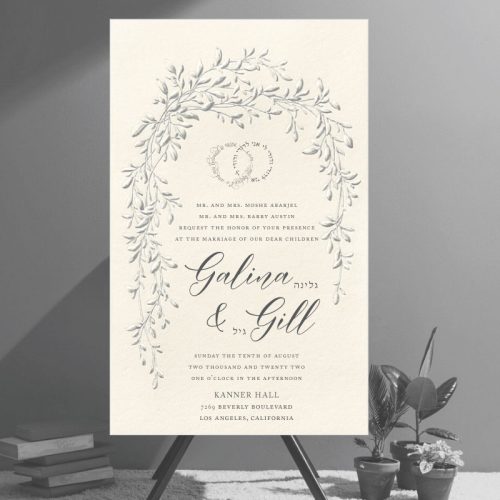 This is not a flat, digitally printed invitation—it's an embossed design that brings true dimension and artistry to the piece. The raised embossing adds depth and texture to a graceful sketch of trailing vines, arching over the text in the symbolic shape of a chuppah. Aptly named the Arched Foliage Chuppah Jewish Wedding Invitation, it captures tradition and elegance in every detail. At the top, the Hebrew phrase Ani L’dodi V’dodi Li (I am my beloved’s and my beloved is mine) appears in the shape of intertwined wedding rings, emphasizing unity and love. The wedding details are arranged in a refined layout, featuring elegant script fonts alongside the Hebrew names of the couple.