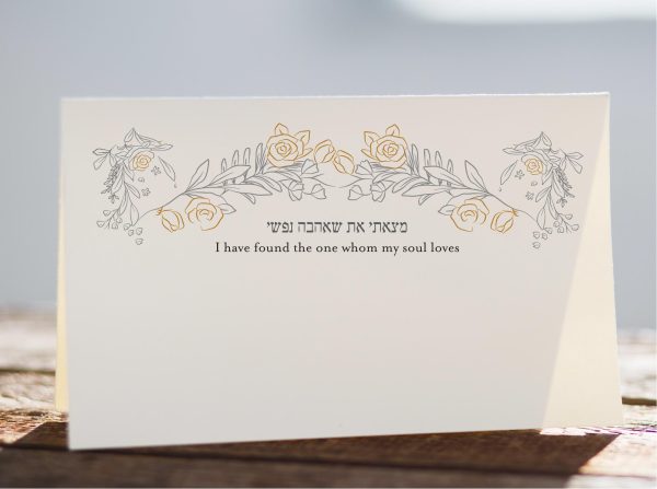 The Gold Roses Arch – Jewish Place Cards epitomize a seamless fusion of modernity and tradition. Each card showcases a stunning arrangement of hand-drawn leaves and roses, creating an exquisite backdrop for your wedding invitation. The Hebrew text 'I found the one whom my soul loves' adds a touch of profound sentiment, capturing the essence of a Jewish wedding with grace and elegance.