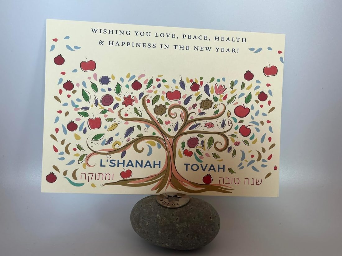 Celebrate Rosh Hashanah in style with our exquisite "Sweet Year" card, adorned with vibrant pomegranates and apples. This unique design beautifully captures the essence of the holiday, ensuring your greetings make a lasting impression. Personalize your card with a special note or signature to add a personal touch that will be cherished for years to come. Our new line of Jewish New Year cards features a sleek, flat design that offers ample space for your customization. Send a distinctive, high-quality card that will stand out and be treasured by your loved ones. Size: 5″ x 7″ (Flat Card) Printed On: Luxurious 130 lb heavy card stock. Made In: 100% in America Included: 5 cards and 5 corresponding envelopes