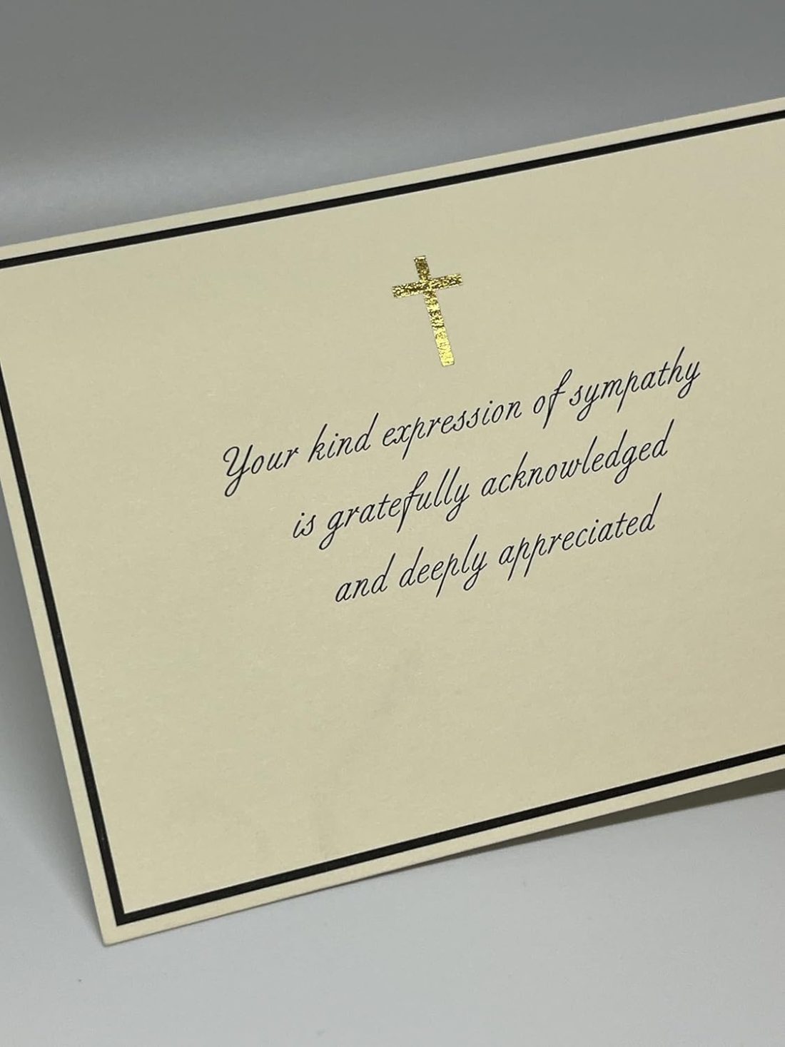 Our Christian Sympathy Thank You Cards provide a graceful and dignified way to acknowledge the kindness of friends and family during a difficult time. This design features a shimmering gold foil cross centered within a sophisticated black border, paired with an elegant script that reads, "Your kind expression of sympathy is gratefully acknowledged and deeply appreciated." Each card is printed on our signature 130lb. premium heavy ecru cardstock using professional presses to ensure a high-end, tactile feel. These are flat note cards, offering a clean and polished look for your personal acknowledgments.
