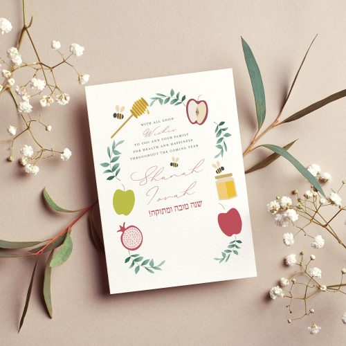 Rosh Hashanah greeting card with watercolor wreath of apples, honey jar, pomegranate and bees, Hebrew text שנה טובה ומתוקה, Shanah Tovah script lettering, cream background